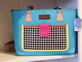 Blue handbag with houndstooth pattern pocket on a shelf