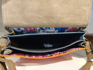 Open beige handbag with colorful interior lining on a light background